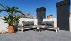 Sonnige Dachterrasse des Penthouses in Nou Llevant mit moderner Lounge-Möblierung und Tropenpalme