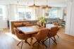 Bright living-dining room with wooden table, rattan chairs and view of Palma's cityscape