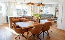 Lichtdurchflutetes Wohn-Esszimmer mit Holztisch, Rattanstühlen und Blick auf Palmas Stadtlandschaft