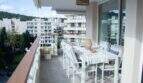 Großzügige Dachterrasse mit weißen Gartenmöbeln und Blick auf Palmas Stadtbild und Grünanlagen