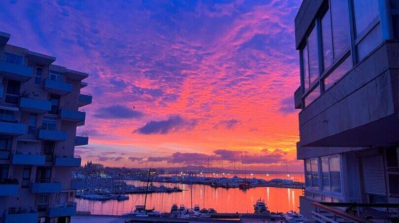 Spektakulärer Sonnenuntergang über dem Hafen von Palma mit Blick auf die Kathedrale vom Balkon der Designerwohnung
