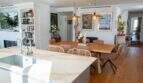 Offener Wohn-Essbereich mit Marmorinsel, Holztisch und Bücherregal in Designerwohnung Palma