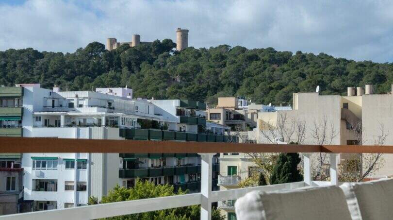 Dachterrasse mit Blick auf Castell de Bellver und Wohngebäude in Palma, umgeben von grüner Vegetation