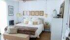 Helles Schlafzimmer mit Doppelbett, Holzboden, Deckenventilator und goldenen Pendelleuchten in Designerwohnung Palma