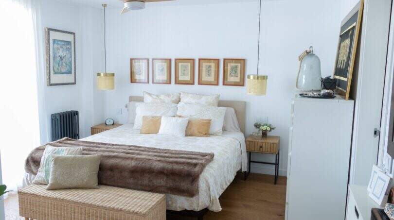 Helles Schlafzimmer mit Doppelbett, Holzboden, Deckenventilator und goldenen Pendelleuchten in Designerwohnung Palma