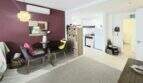 Living area with dining table, air conditioning & open kitchen, bordeaux accent wall, Palmanova