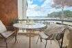 Balcony of the apartment in Palmanova with sea view, rattan chairs and white wine bottle on round table