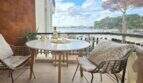 Balcony of the apartment in Palmanova with sea view, rattan chairs and white wine bottle on round table