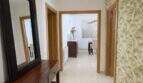 Eleganter Flur mit Tropenblatt-Tapete, Holzkonsole, Spiegel und Blick ins Esszimmer in Palma-Villa