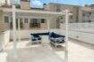 Sonnige Dachterrasse mit weißer Pergola, blauer Lounge-Möblierung und Stadtblick in Palma de Mallorca