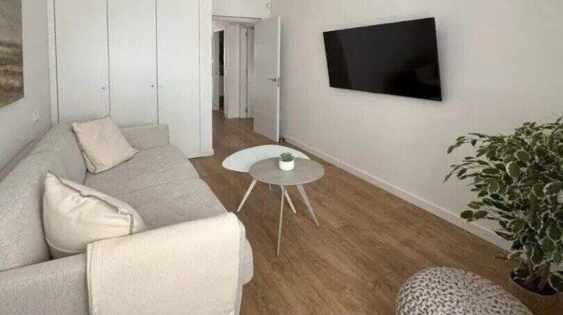 Helles Wohnzimmer mit Sofa, Couchtisch, Flachbild-TV und Holzböden im Penthouse Palma de Mallorca