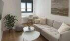 Helles Wohnzimmer des Penthouses in Palma mit Sofa, Holzboden, Schreibtischbereich und modernem Dekor.