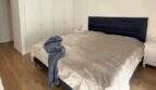 Helles Schlafzimmer im Penthouse Palma mit Doppelbett, schwarzem Polsterkopfteil und weißem Einbauschrank