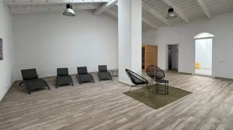 Heller Spa-Ruheraum mit Liegestühlen, Loungesesseln und Holzboden unter weißem Sparrendach im Penthouse Palma