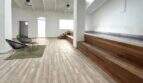 Geräumiger Wohnbereich mit Holzboden, weißen Wänden und erhöhtem Indoor-Pool mit Holzverkleidung im Penthouse Palma