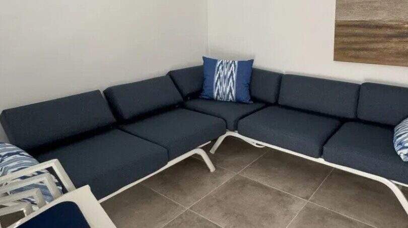 Überdachte Terrasse mit blauer L-Sofa-Garnitur und weißem Rahmen im Penthouse Palma de Mallorca