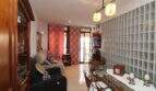 Living room with glass block wall, sofa landscape, dining table and balcony access in Palma de Mallorca