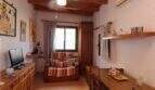 Cozy living room with wooden beam ceiling, armchair, TV and air conditioning in Palma de Mallorca