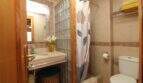 Bathroom with shower, toilet, sink and glass block wall in a multi-family building in Palma de Mallorca.