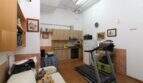 Open living area with kitchenette, treadmill and sofa in a building with development potential in Palma