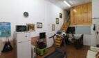 Multi-purpose room with treadmill, refrigerator, microwave and wooden staircase to upper floor in Palma