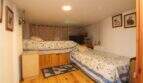 Bedroom with two single beds, wooden floor and wall paintings in a building in Palma de Mallorca.