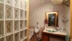 Bathroom with glass block wall, decorative sink, bidet and wooden base cabinet in Palma