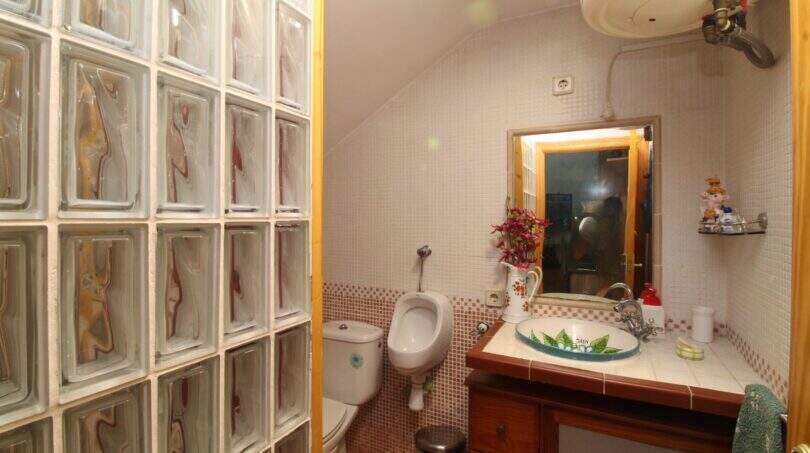 Bathroom with glass block wall, decorative sink, bidet and wooden base cabinet in Palma