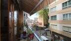 Balcony with awning, plants and city view of Palma de Mallorca, multi-story residential buildings in the background