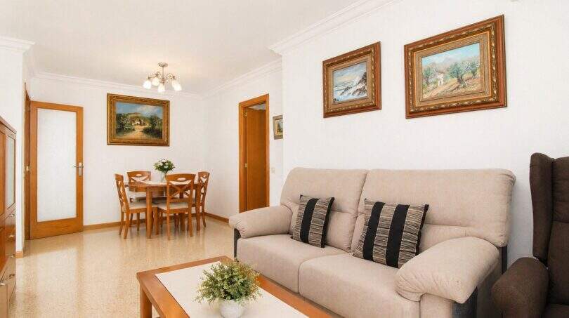 Helles Wohnzimmer mit Sofa, Couchtisch und Essbereich in Wohnung in Portixol, Palma de Mallorca
