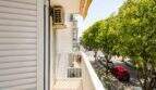 Balkon der Wohnung in Portixol mit Blick auf baumgesäumte Straße, Klimaanlage und Jalousien