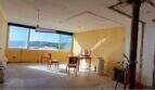 Renovierungsbedürftiger Wohnraum im Penthouse-Loft mit großen Fenstern und Meerblick auf Palma de Mallorca.