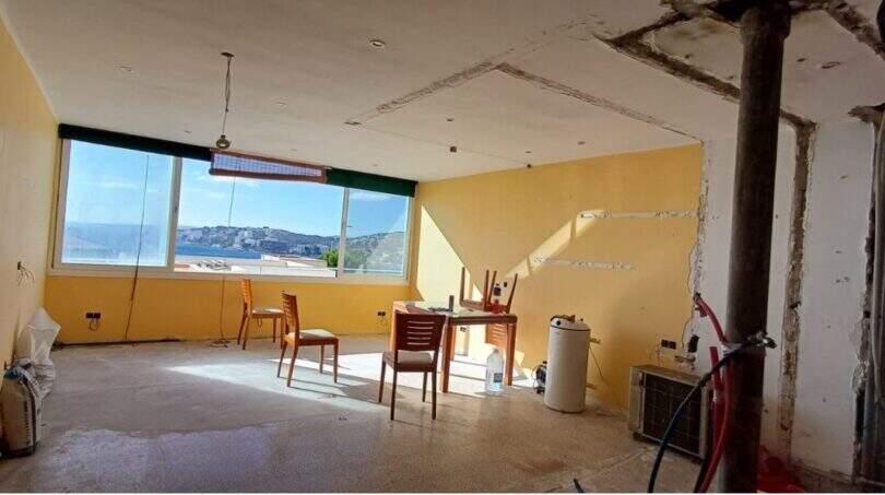 Renovierungsbedürftiger Wohnraum im Penthouse-Loft mit großen Fenstern und Meerblick auf Palma de Mallorca.