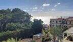 Panoramablick vom Penthouse-Loft in Palma: üppige Pinien, historische Villa und glitzerndes Mittelmeer.