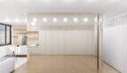 Helles Loft-Wohnzimmer mit weißen Einbauschränken, Marmorboden und moderner Küche im Penthouse Palma