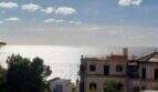 Meerblick vom Penthouse-Loft in Palma mit historischer Villa und glitzerndem Mittelmeer unter blauem Himmel