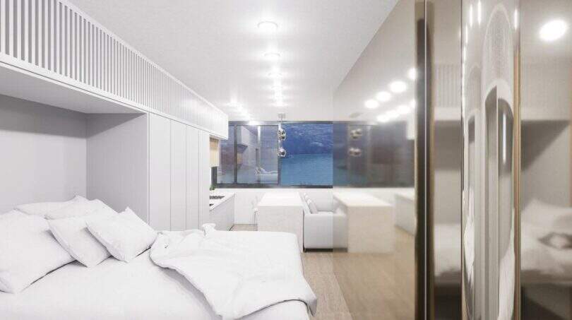 Helles Penthouse-Schlafzimmer mit weißem Doppelbett, modernem Design und Meerblick durch großes Panoramafenster