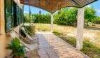 Terraza cubierta de la finca mallorquina en Lloret de Vistalegre con tumbonas y vista al jardín