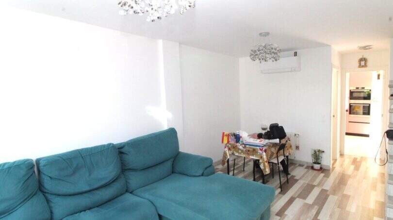 Helles Wohnzimmer mit türkisem Sofa, Esstisch und Kronleuchter im Reihenhaus nahe Strand, Palma de Mallorca