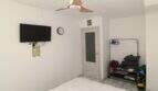 Helles Schlafzimmer mit Deckenventilator, Wand-TV, Uhr und Kleiderständer im Reihenhaus nahe Strand Palma