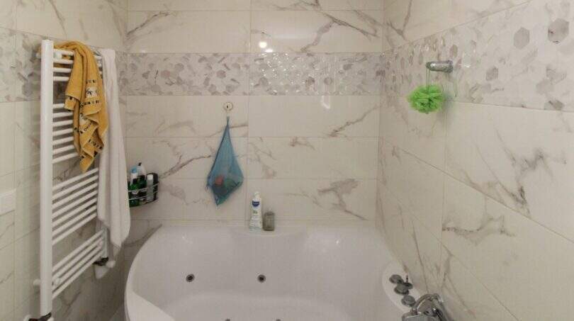 Badezimmer mit Whirlpool-Eckbadewanne, Marmorfliesen und Handtuchheizkörper im Reihenhaus Palma de Mallorca