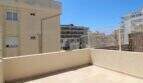 Helle Dachterrasse mit Fliesenbelag und Metallgeländer, umgeben von mediterranen Stadtgebäuden in Palma de Mallorca.