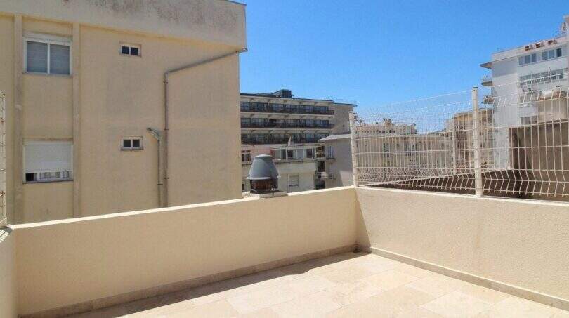 Helle Dachterrasse mit Fliesenbelag und Metallgeländer, umgeben von mediterranen Stadtgebäuden in Palma de Mallorca.