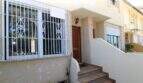 Hauseingang mit Treppe, Holztür und Sicherheitsgitter am Fenster eines Reihenhauses in Palma de Mallorca