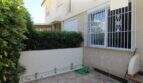 Kleiner Innenpatio mit Fliesenboden, Hecke, Eisengitter-Fenstern und Gartenbeleuchtung eines Reihenhauses in Palma