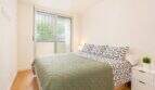 Helles Schlafzimmer der Palma-Wohnung mit Doppelbett, Parkettboden und Zugang zur Terrasse.