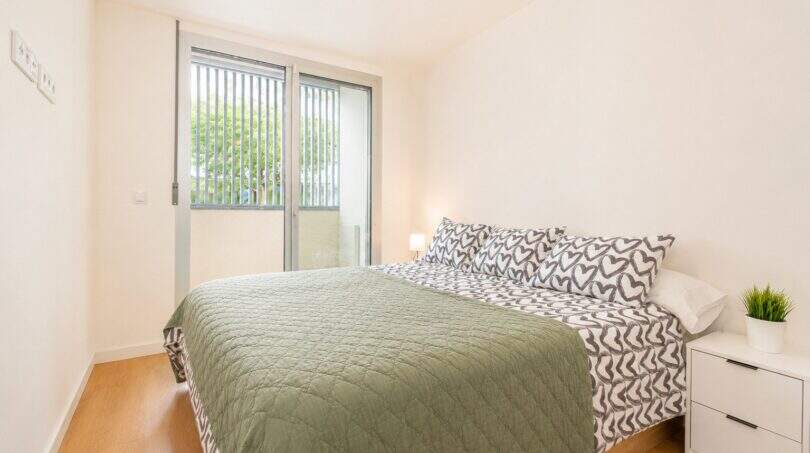 Helles Schlafzimmer der Palma-Wohnung mit Doppelbett, Parkettboden und Zugang zur Terrasse.