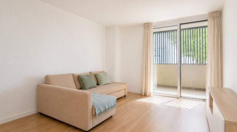 Helles Wohnzimmer mit Beige-Sofa, Holzboden und Balkonzugang in exklusiver Wohnung in Palma