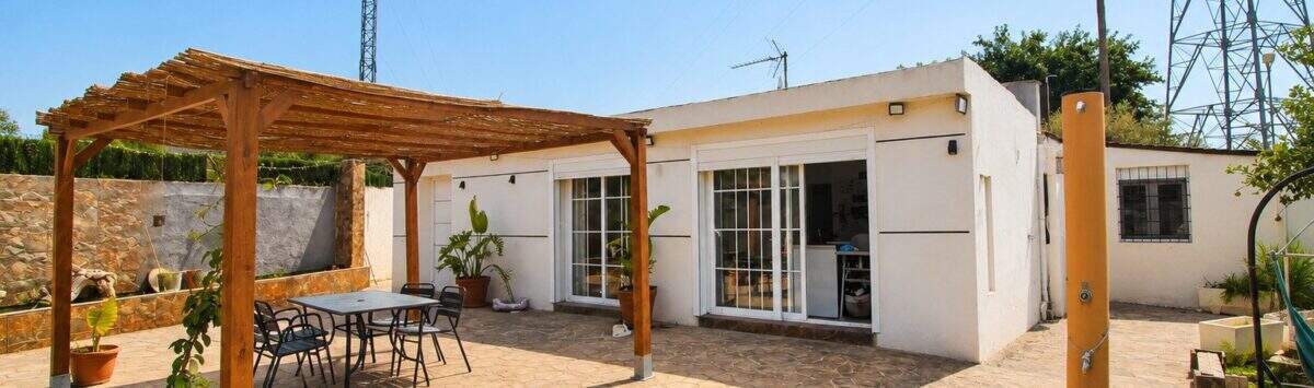 Sonnige Terrasse mit Holzpergola und Sitzbereich einer Finca bei Palma de Mallorca