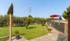 Gepflegter Garten mit Rasenfläche, Schaukel, Trampolin und Sonnenschirm der Finca bei Palma de Mallorca